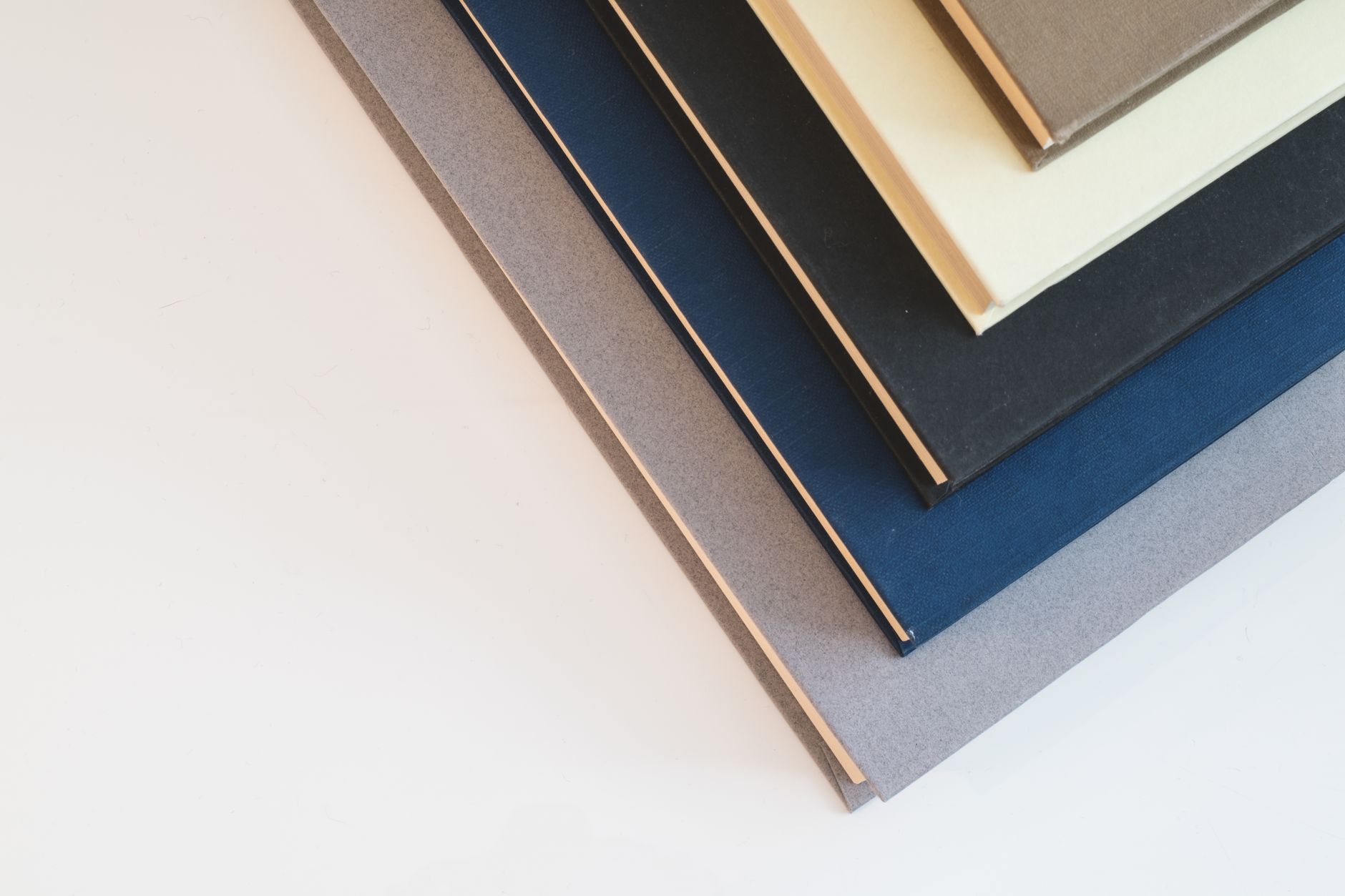 A stack of hardcover books in varied colours, seen from above